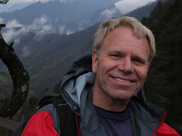 Tom Serfass in kayaking gear, with a mountain in the background