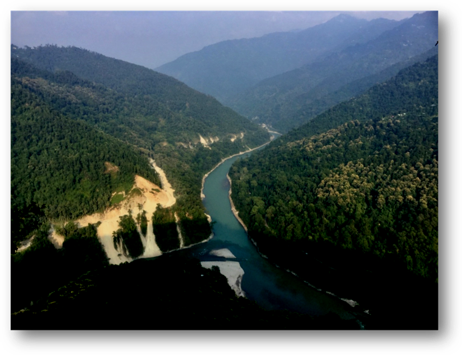 River in steep sided gorge winding between densely forested hills, with occasional shallower river banks. 